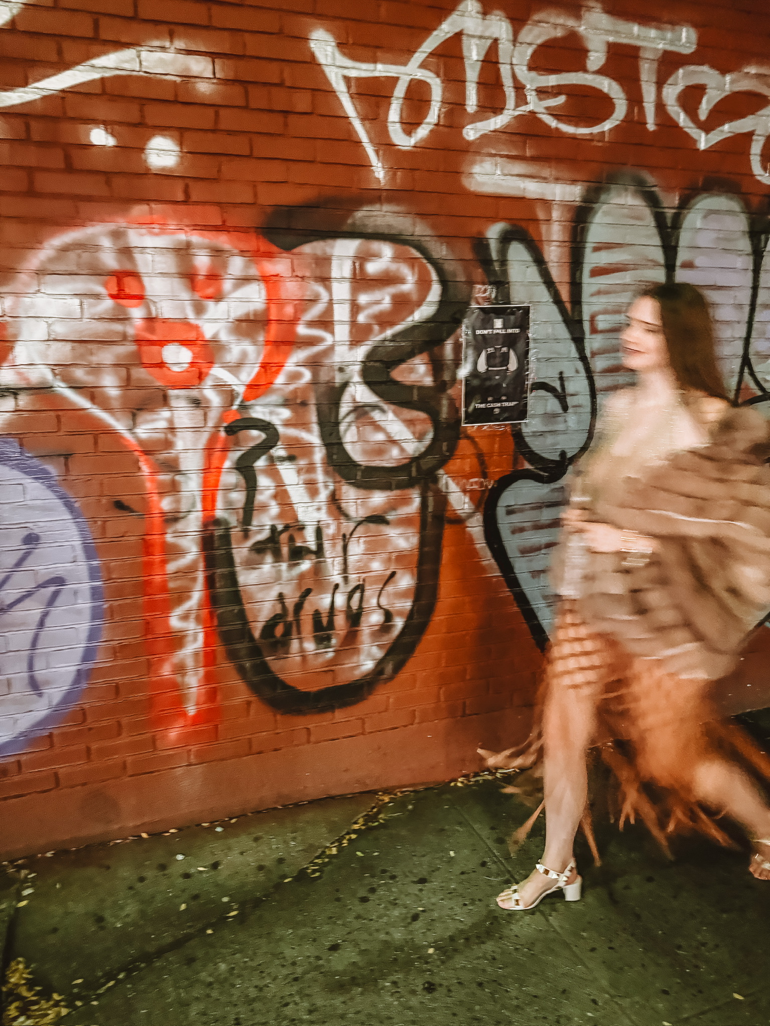 my new york fashion week experience, amy's daughter kelley walking in front of a graffiti wall 